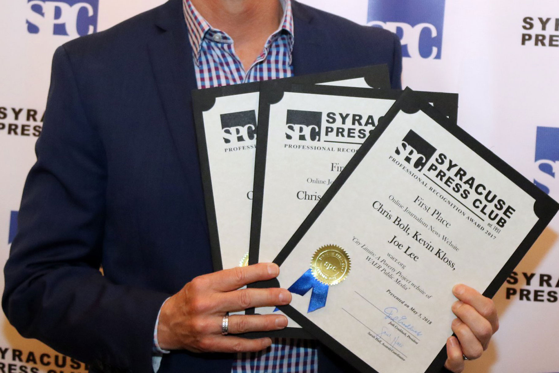 Award winner holding certificates